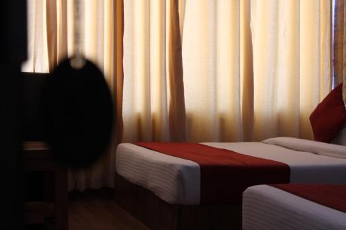 a room with two beds and a window with curtains at Black Diamond Hotel & Spa in Zirakpur