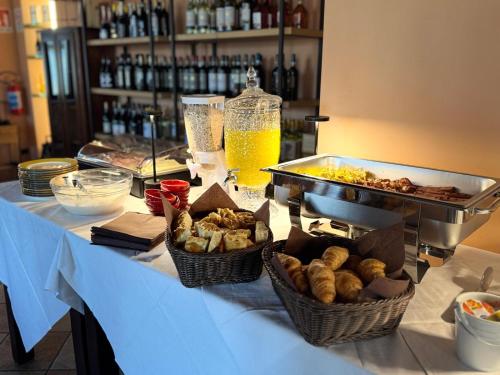 a buffet with baskets of food and drinks on a table at Albergo Tenco by Bottega in Alice Bel Colle