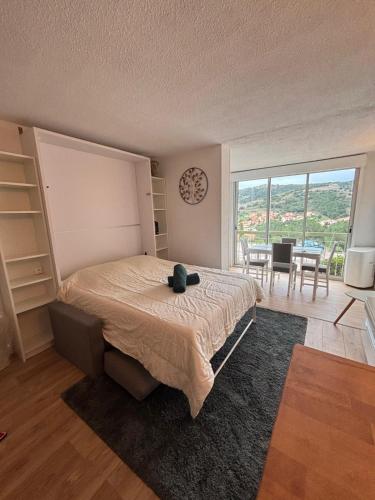 - une chambre avec un grand lit et une salle à manger dans l'établissement Résidence avec Parking Viva Collioure, à Collioure