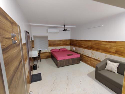 una habitación con una cama, una mesa y un sofá en Central Stay, en Godāvari