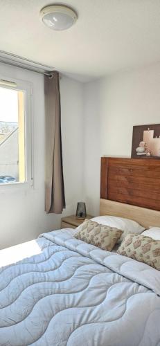 une chambre avec un grand lit et une fenêtre dans l'établissement Le Nid Bleu Confort & Mer à Pied, à Cayeux-sur-Mer