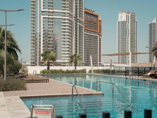 a swimming pool in a city with tall buildings at Modern Studio Escape - Pool, Gym & Relaxation in Dubai
