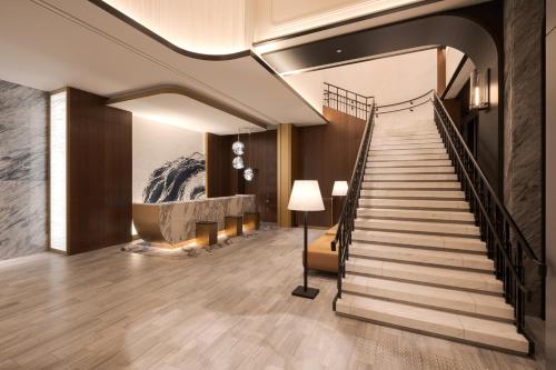 a staircase in a lobby with a stair case at Premier hotel -CABIN PRESIDENT- Tokyo in Tokyo