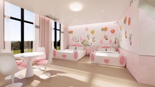 a childs room with two beds and a table at The Siena PRIMO in Seogwipo