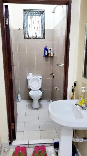 a bathroom with a toilet and a sink at PureBliss Homes in Mombasa