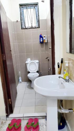 a bathroom with a white sink and a toilet at PureBliss Homes in Mombasa