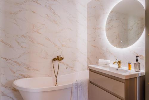 a bathroom with a tub and a sink and a toilet at Saku Manor & Beerspa in Saku