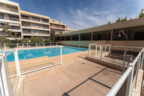 un immeuble avec une piscine devant un immeuble dans l'établissement Magnifique Appartement, Piscine, Proche gare, à Beaulieu-sur-Mer