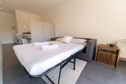 a bed with two towels on it in a room at Magnifique Appartement, Piscine, Proche gare in Beaulieu-sur-Mer