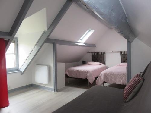 une chambre mansardée avec deux lits et une fenêtre dans l'établissement Maison de pêcheur - 250 m plage - Terrasse privée, à Étretat