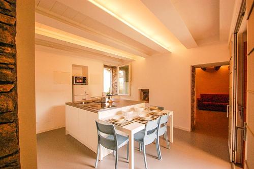 a kitchen with a white table and chairs in a room at Rustico Moderno in Ghiffa