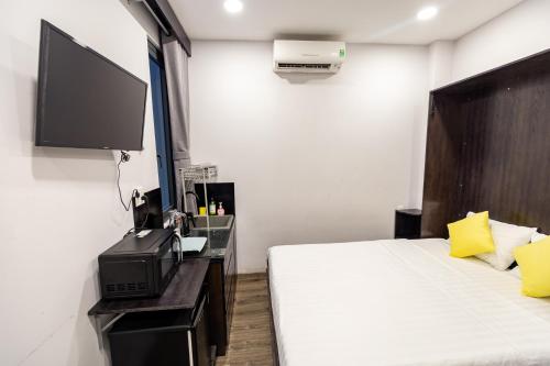 a bedroom with a bed and a flat screen tv at Brand New Cozy Home in D1 wBalcony in Ho Chi Minh City