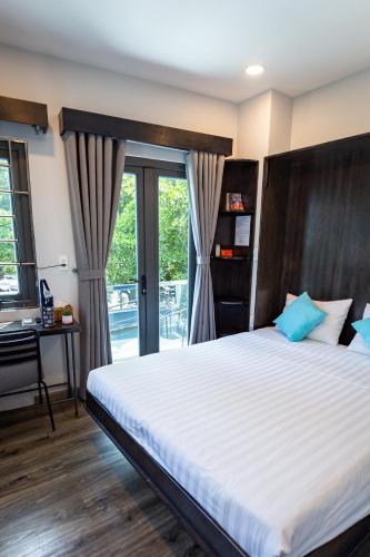 a bedroom with a bed and a desk and a window at Brand New Cozy Home in D1 wBalcony in Ho Chi Minh City