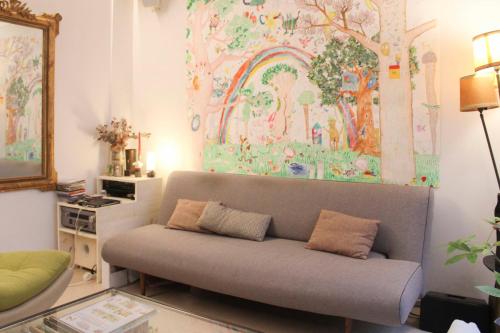 - un canapé dans le salon orné d'une peinture murale dans l'établissement Haven of peace with private terrace, à Paris