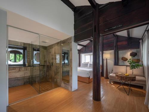 a bathroom with a shower and a bedroom with a bed at The Bivou Lijiang in Lijiang