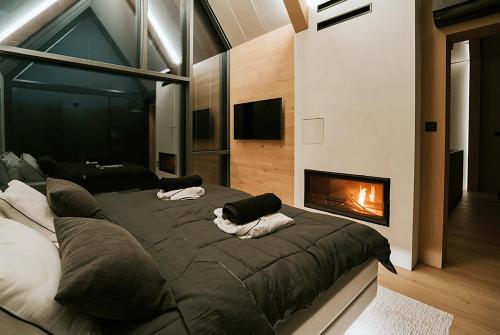 a bedroom with a large bed with a fireplace at Fenyőhegy Luxus Pihenőház Mátrakeresztes in Matrakeresztes