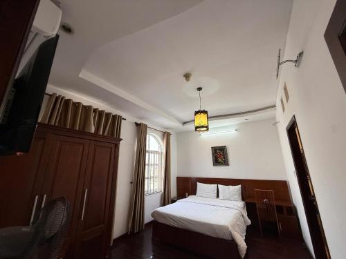 a bedroom with a bed and a tv in it at Hoa Phat Hotel & Apartment in Ho Chi Minh City