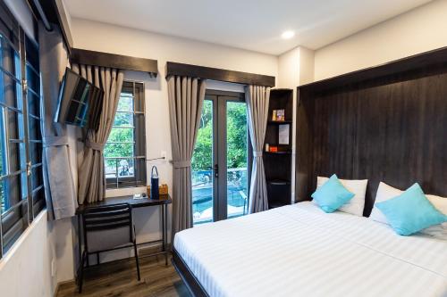 a bedroom with a bed and a desk and a window at Brand New Cozy Home in D1 wBalcony in Ho Chi Minh City