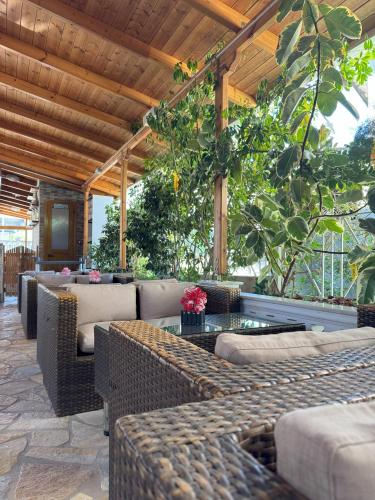 an outdoor patio with wicker furniture and a table at Garden Villa Veli in Ksamil
