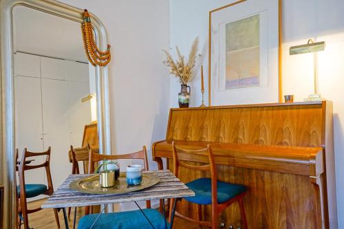 une salle à manger avec une table et un piano dans l'établissement Beautiful apartment with view on the Faubourg, à Paris