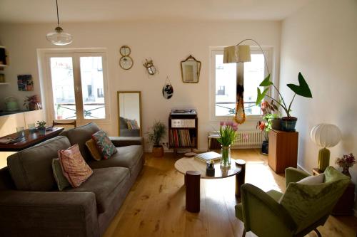 un salon avec un canapé et une table dans l'établissement Beautiful apartment with view on the Faubourg, à Paris