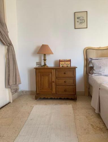 a bedroom with a bed and a lamp on a dresser at L'Authenticité in Sidi Bou Saïd