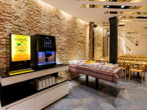 a restaurant with a television and tables and chairs at Barcelona House in Barcelona