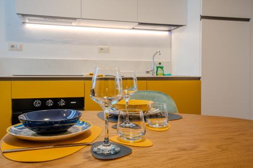 a table with two wine glasses and a bowl on it at Case Ospitali - Casa La Fontanella, suggestivo bilocale x2 in corte in Cernusco sul Naviglio