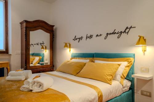 a bedroom with a bed with a mirror and towels at Case Ospitali - Casa La Fontanella, suggestivo bilocale x2 in corte in Cernusco sul Naviglio