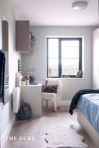a bedroom with a bed and a desk and a window at The Duke Maynooth in Maynooth