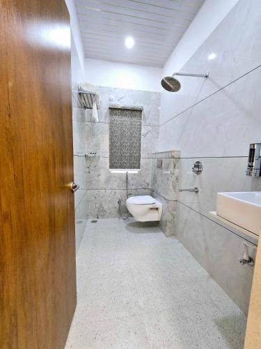 a bathroom with a toilet and a sink at Vaikuntha Stays Hotel in Indore