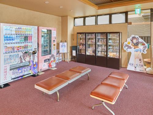 a waiting room with two chairs and vending machines at Aso uchinomaki DAIKANSOU in Aso