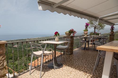 a restaurant with a balcony with tables and chairs at La Pastorella Boutique Hotel in Diamante