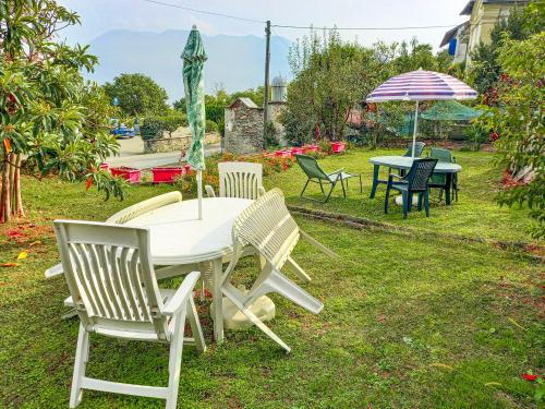 a table and chairs and an umbrella in the grass at Rustico Moderno in Ghiffa