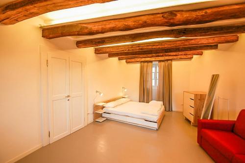 a room with a bed and a red couch at Rustico Moderno in Ghiffa