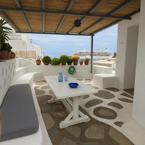 a patio with a table and a laptop on it at Mykonos Seaview Nests - Tourlos Getaways in Tourlos
