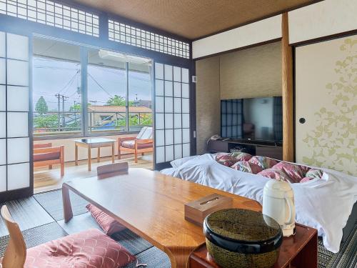 a living room with a couch and a table at Aso uchinomaki DAIKANSOU in Aso