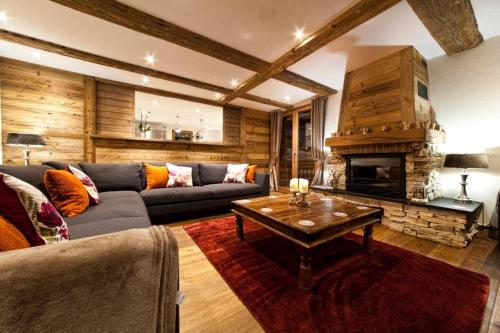 un salon avec un canapé et une cheminée dans l'établissement Chalet Pleney, à Morzine