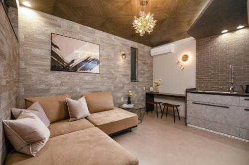 a living room with a couch and a kitchen at JAPAVISTA Luminous in Osaka
