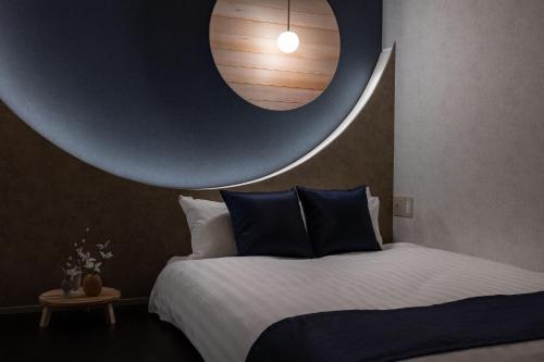 a bedroom with a large bed with a large orb on the wall at JAPAVISTA Luminous in Osaka