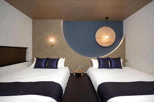 a hotel room with two beds with blue pillows at JAPAVISTA Luminous in Osaka