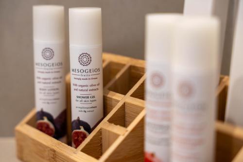 a wooden box with three bottles of moisturizing products in it at Selected Suites in Chania Town