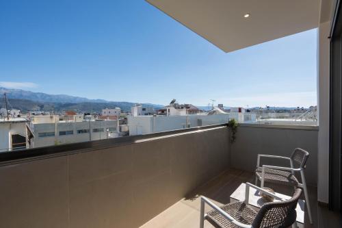 a balcony with two chairs and a view of a city at Selected Suites in Chania Town