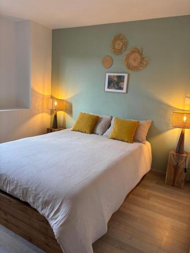 une chambre avec un grand lit blanc avec deux lampes dans l'établissement La Grange de Jannine et Clémentine, à Saint-Germain-la-Chambotte