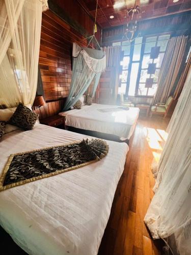 a bedroom with two beds with curtains on them at Homestay Thác Liên Khương in Ðưc Trọng