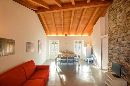 a living room with a red couch and a table at Rustico Moderno in Ghiffa