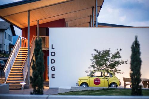 a small yellow car parked in front of a building at Hotel Platz in Ortisei