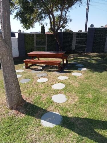 a picnic table sitting in the grass next to a tree at Mandoo guesthouse in Despatch