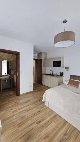 ein weißes Schlafzimmer mit Bett und Küche in der Unterkunft Willa Zacisze Szczawnica Apart in Szczawnica