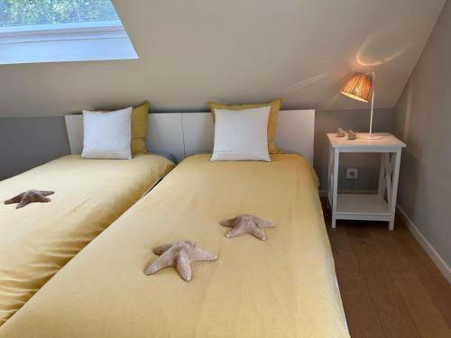 two beds with two star cushions on them in a room at Z' Evita in Nieuwpoort